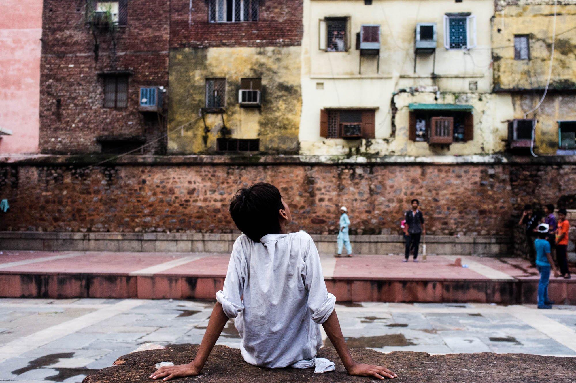 Boy watching cricket in the basti